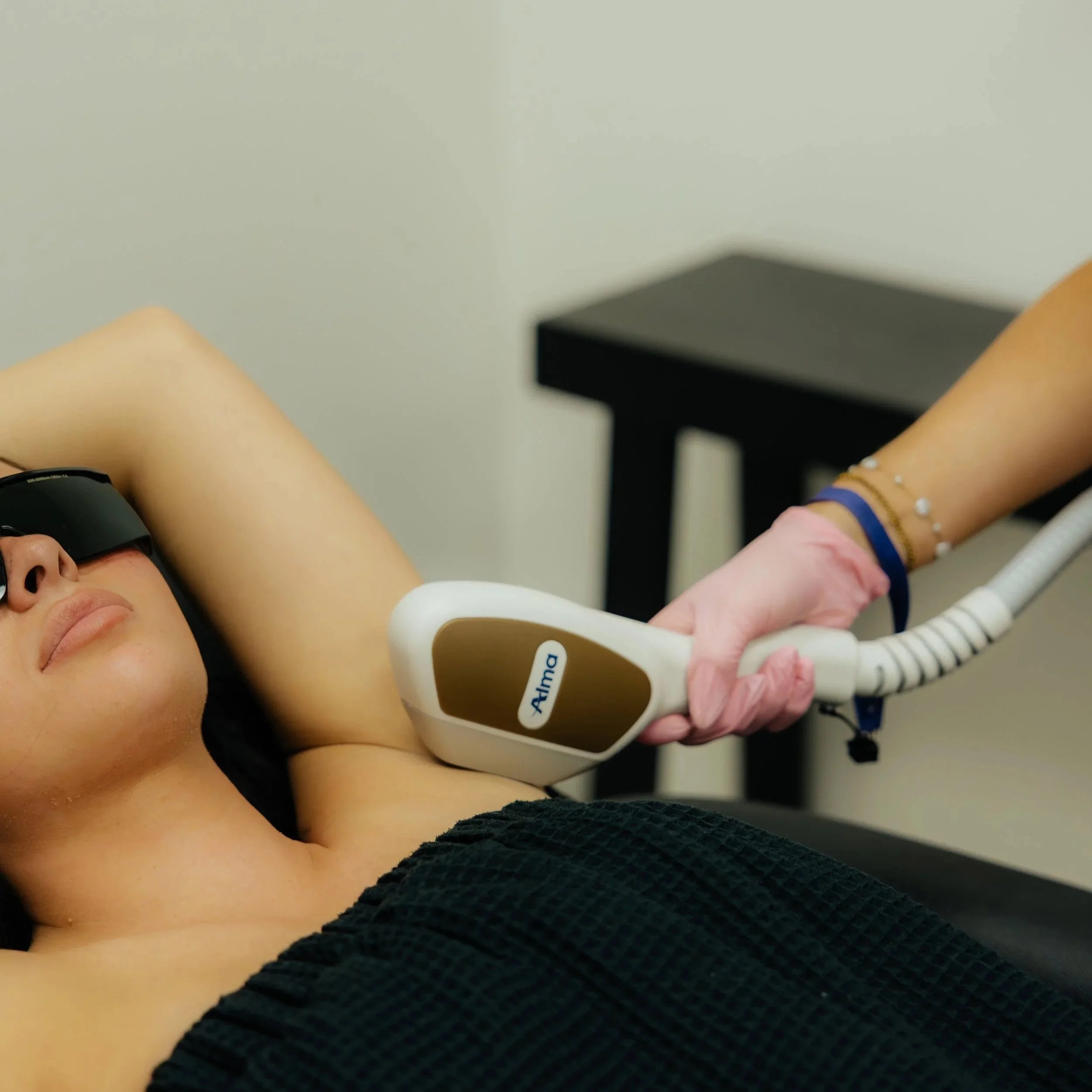 A client wearing protective eyewear during underarm laser hair removal at Mrakki