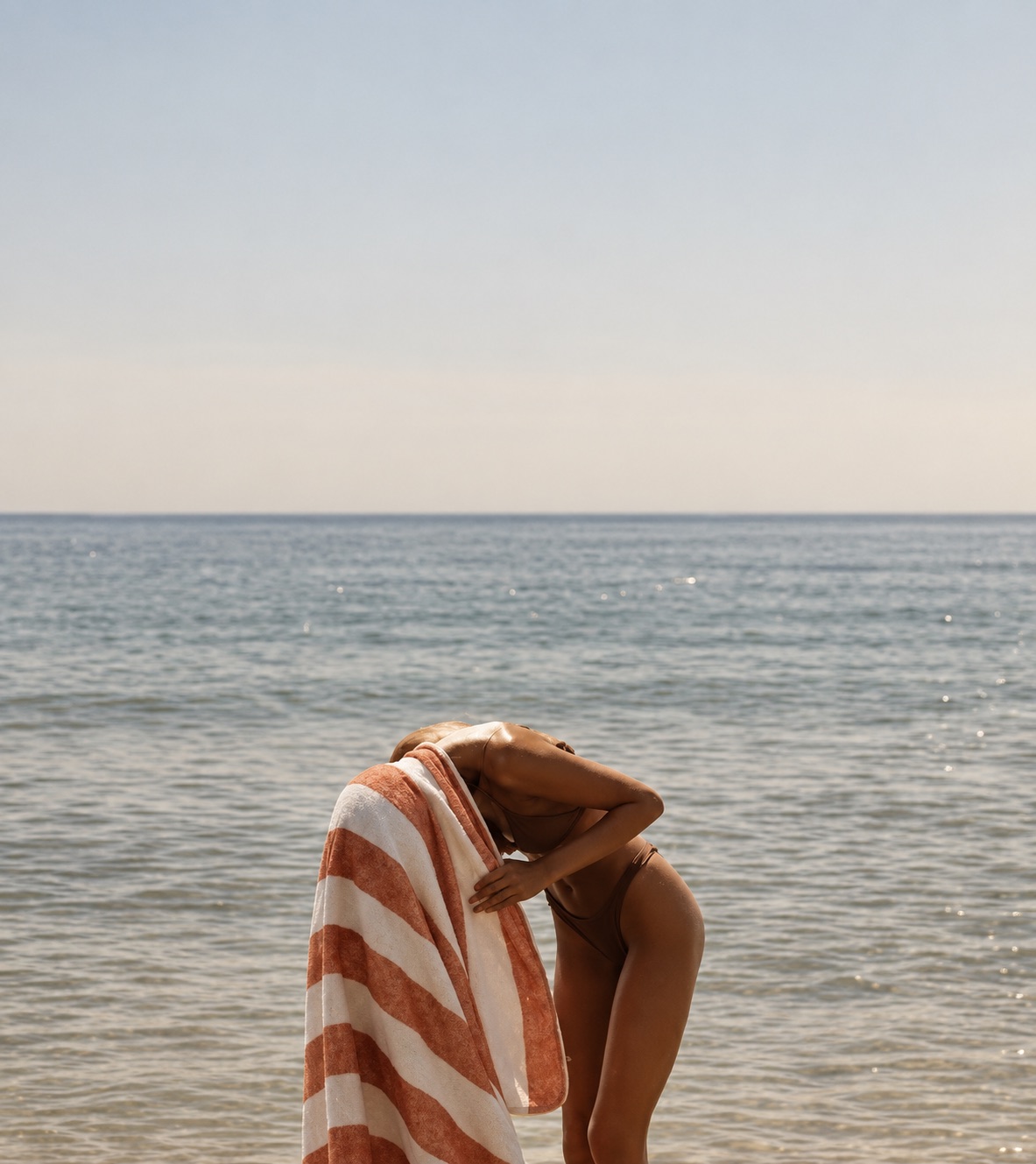 A striped beach towel at the water’s edge