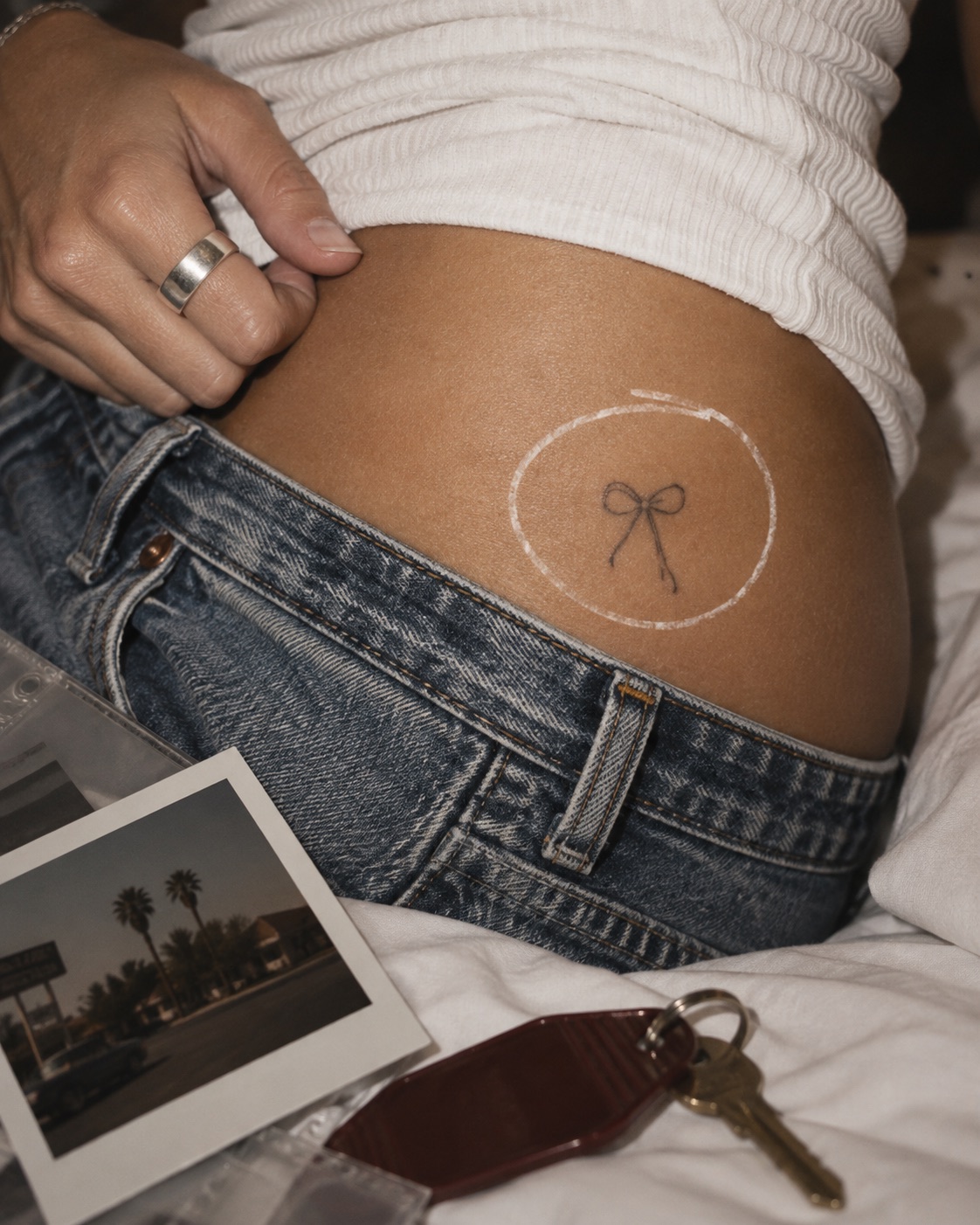 Archived campaign: a close-up of a bow tattoo circled in white beside printed photographs