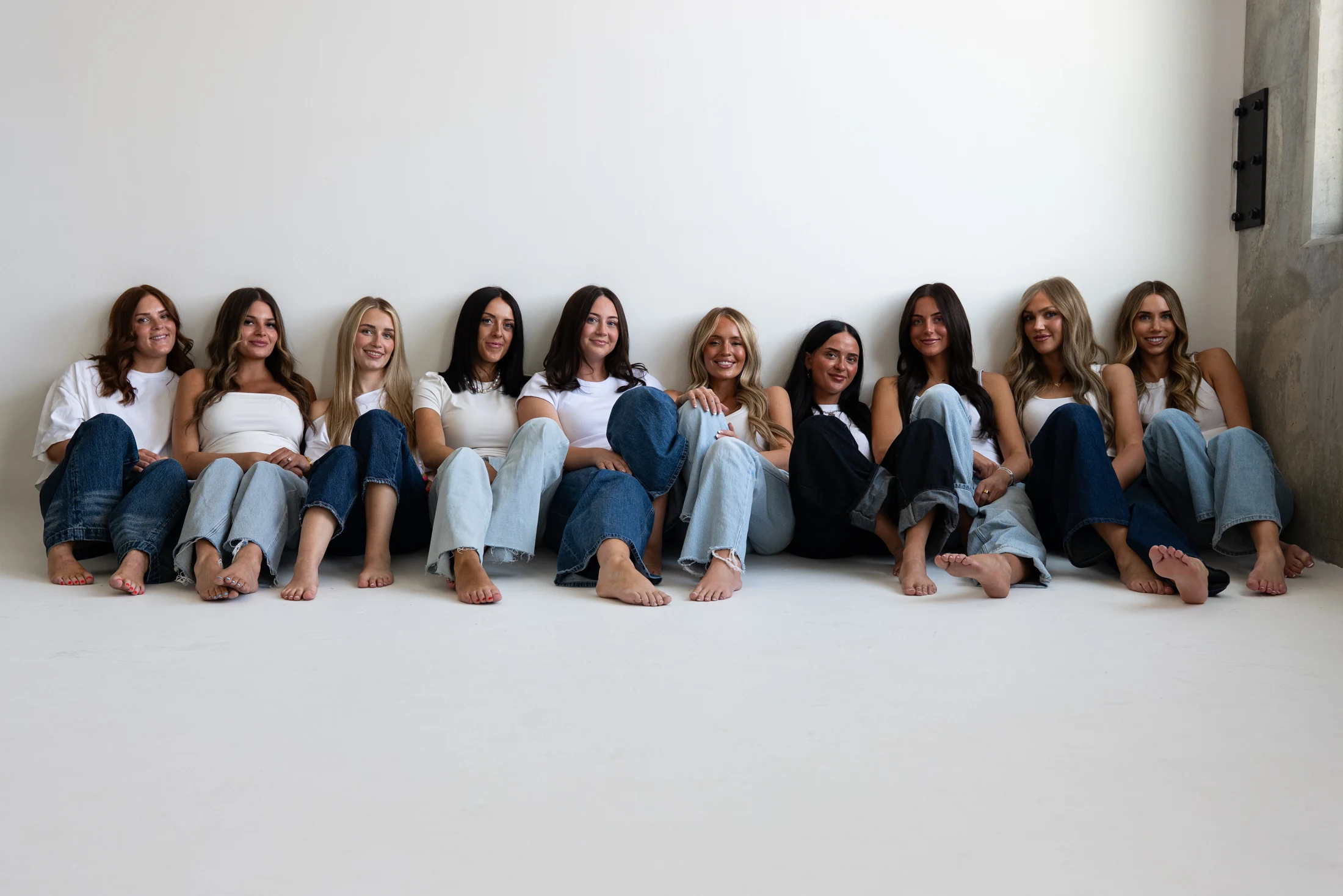The Mrakki team seated together in white tops and denim